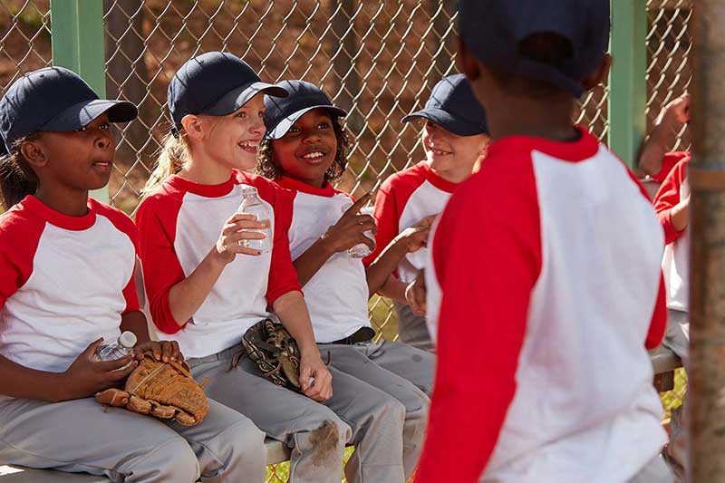 team drinking bottled water in dugout
